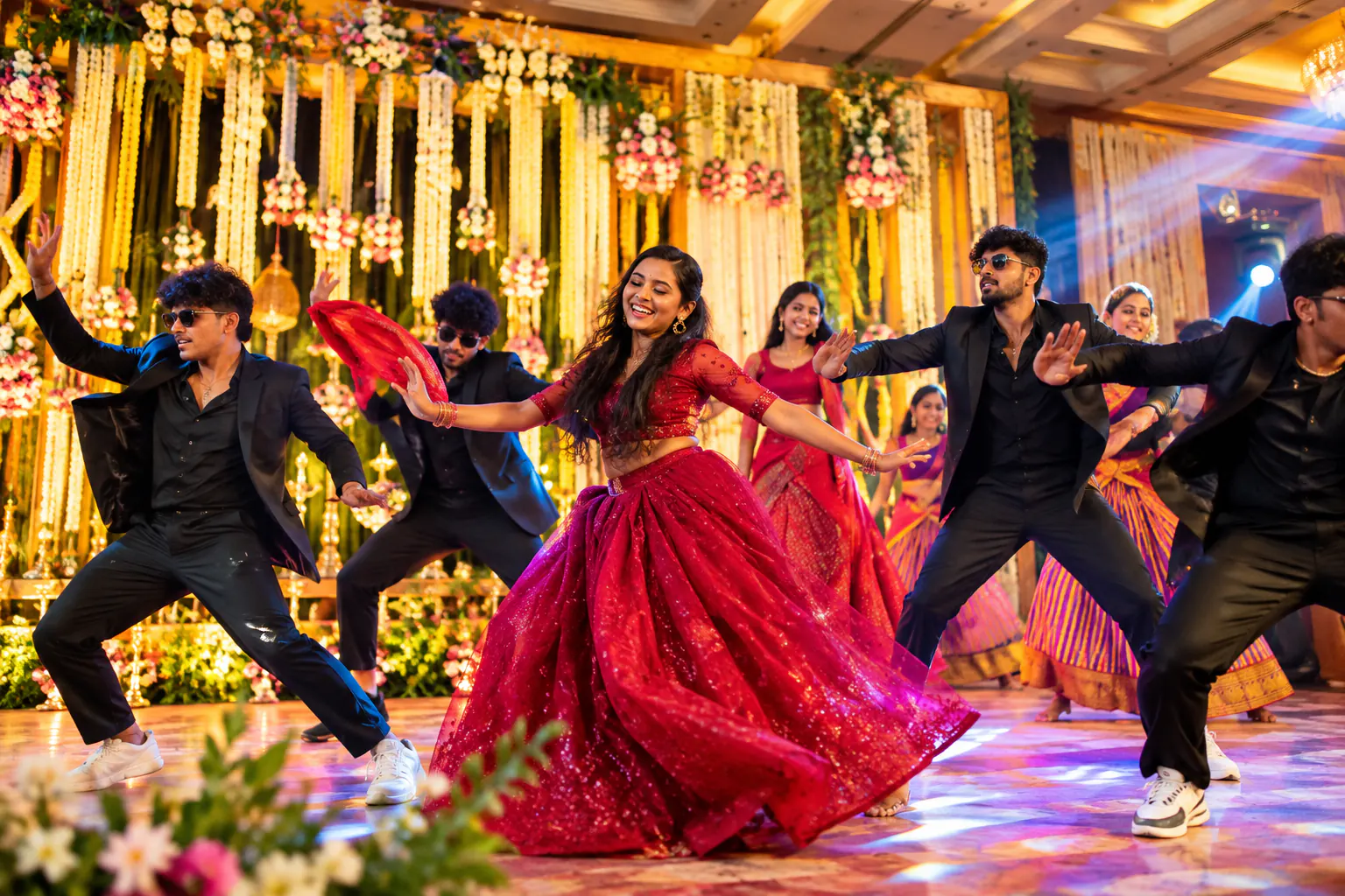Bride and friends performing a choreographed wedding dance on a floral stage
